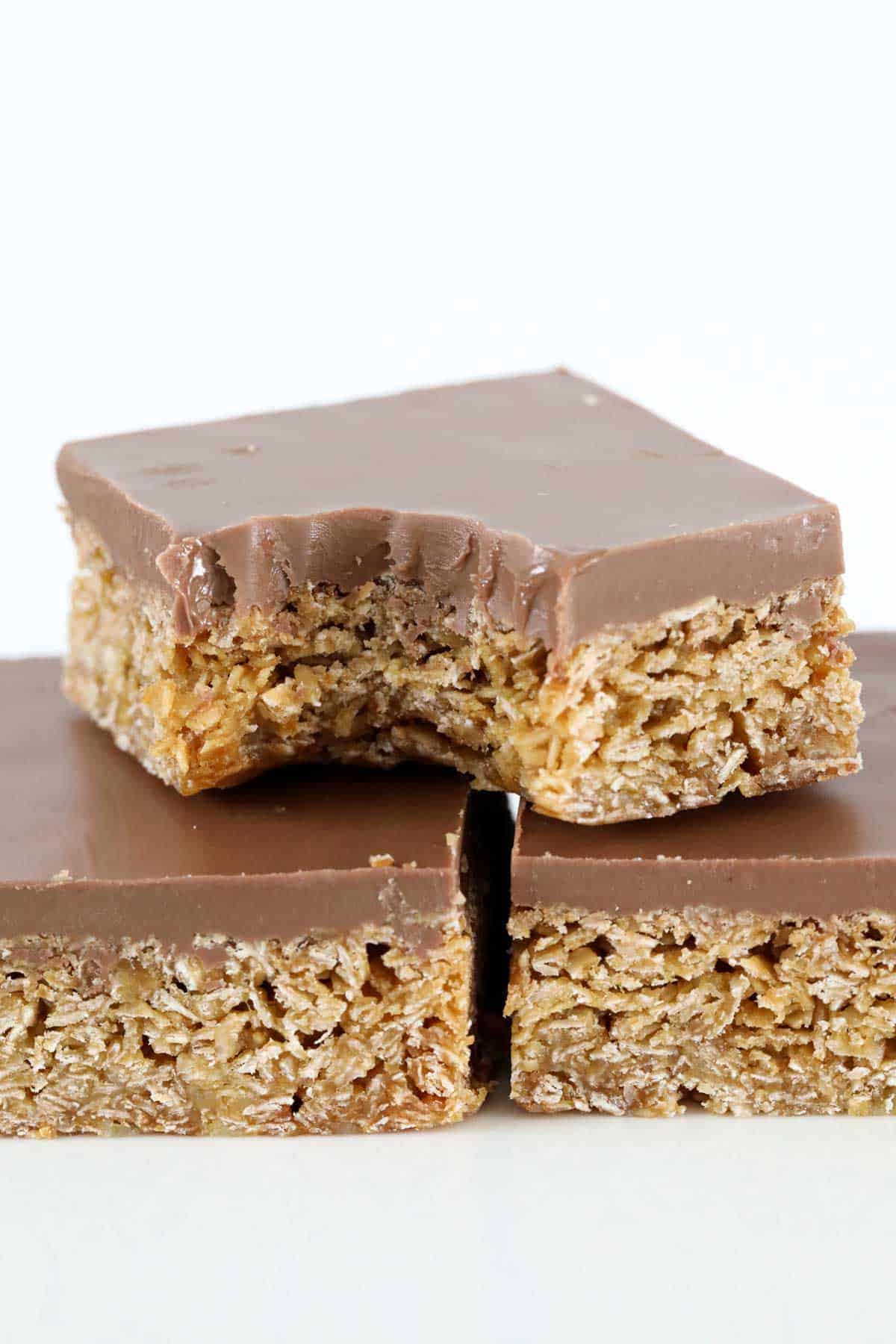 A stack of crunchy chocolate slice with a bite taken out of the top one.