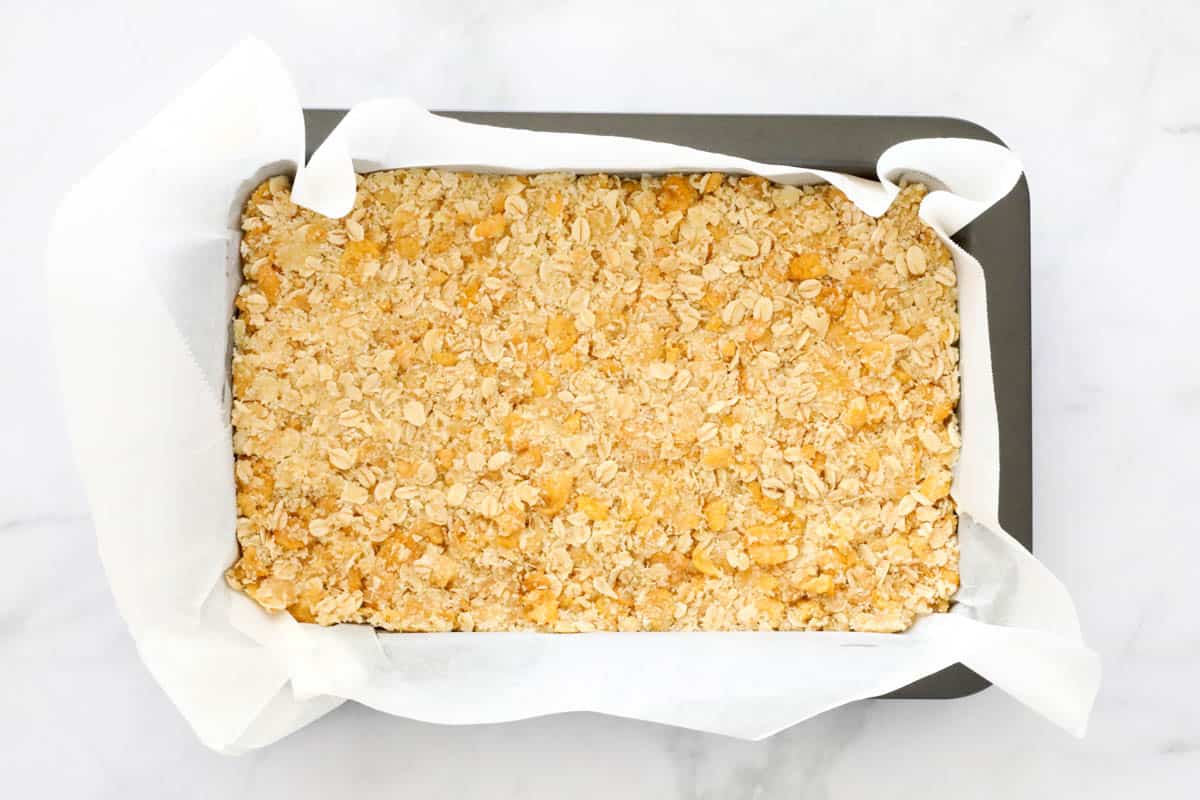 Oats and corn flake slice pressed into a paper lined baking tin.