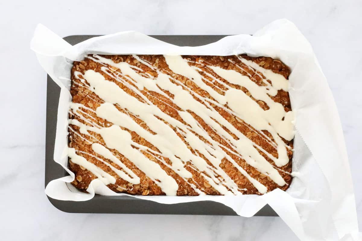 White chocolate drizzled over the top of a baked slice.