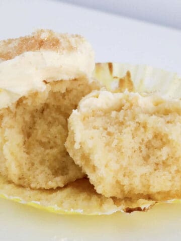 A half eaten lemon cupcake with buttercream.