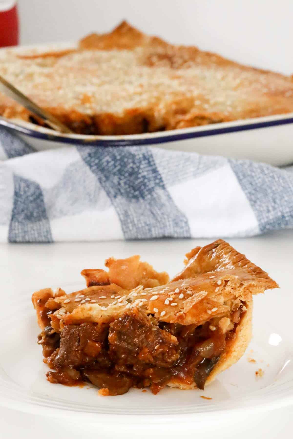 A serve of steak and mushroom pie with chunks of beef visible, on a white plate.