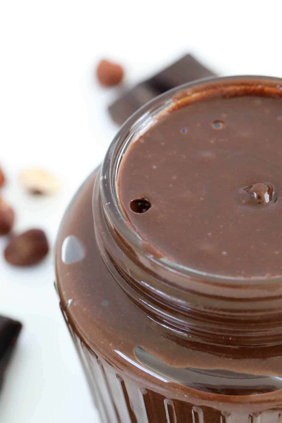 A close up of a glass jar filled with homemade chocolate hazelnut spread.