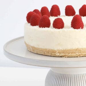 A white chocolate cheesecake topped with raspberries.
