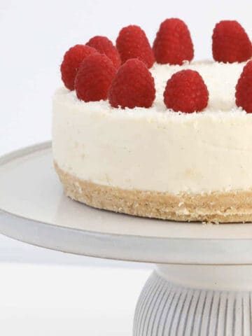 A white chocolate cheesecake topped with raspberries.