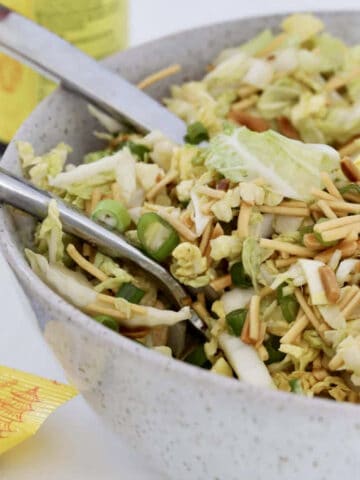 A bowl of cabbage salad with noodles.
