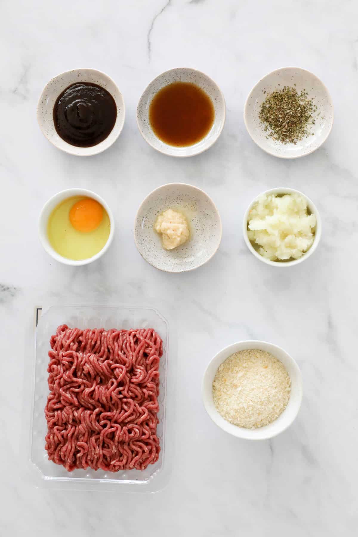 Ingredients to make beef patties in small bowls.