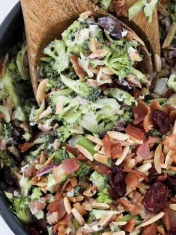 An overhead shot of a broccoli salad with bacon, almonds, cranberries and a creamy dressing.