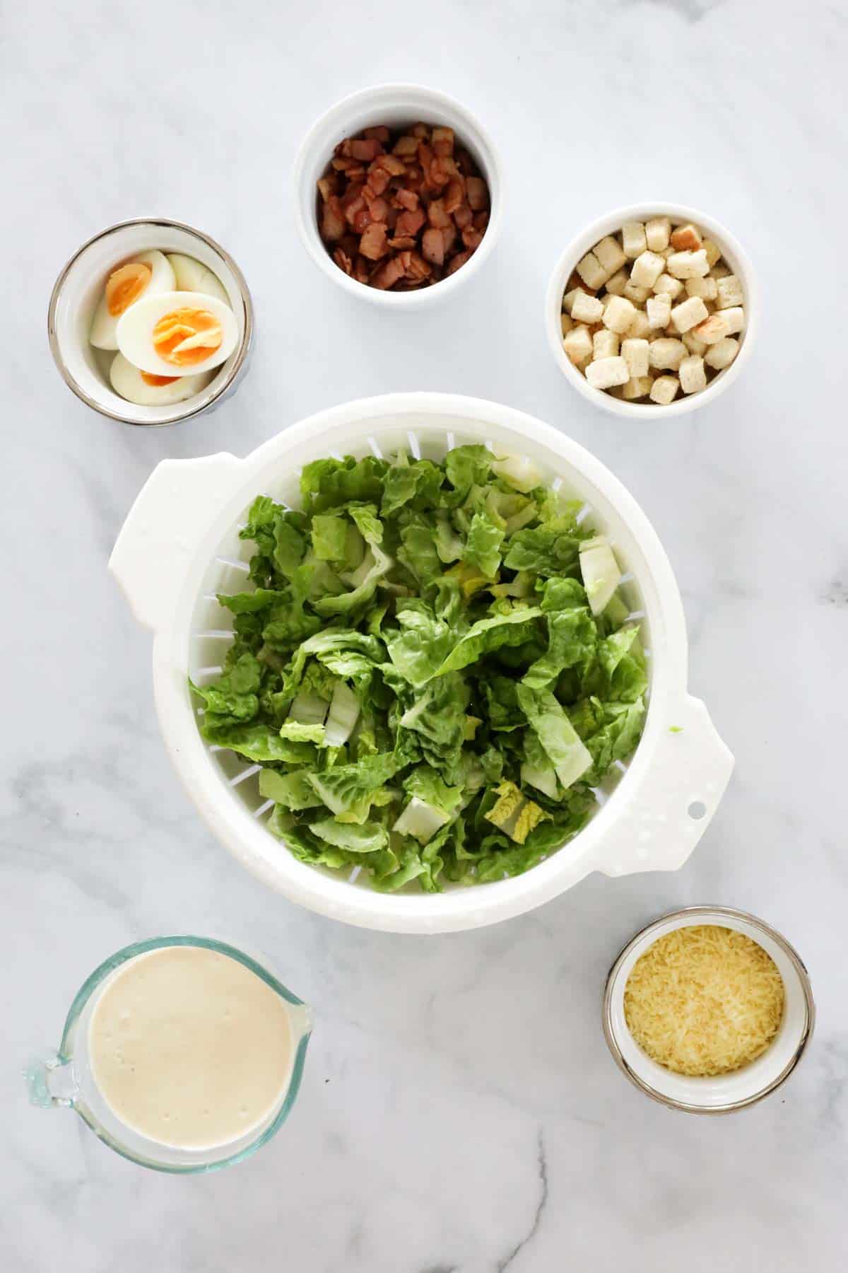 Ingredients for making caesar salad in bowls.