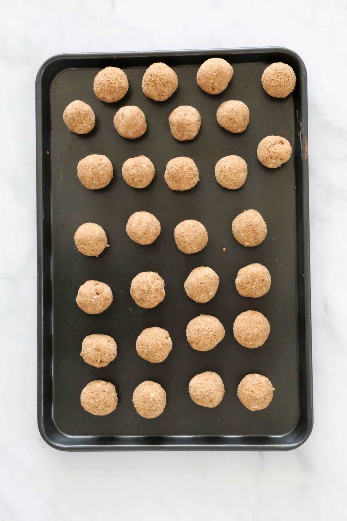 Cream cheese and biscuit mixture rolled into balls and placed on a baking tray