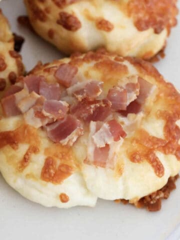 Round rolls topped with bacon and cheese.