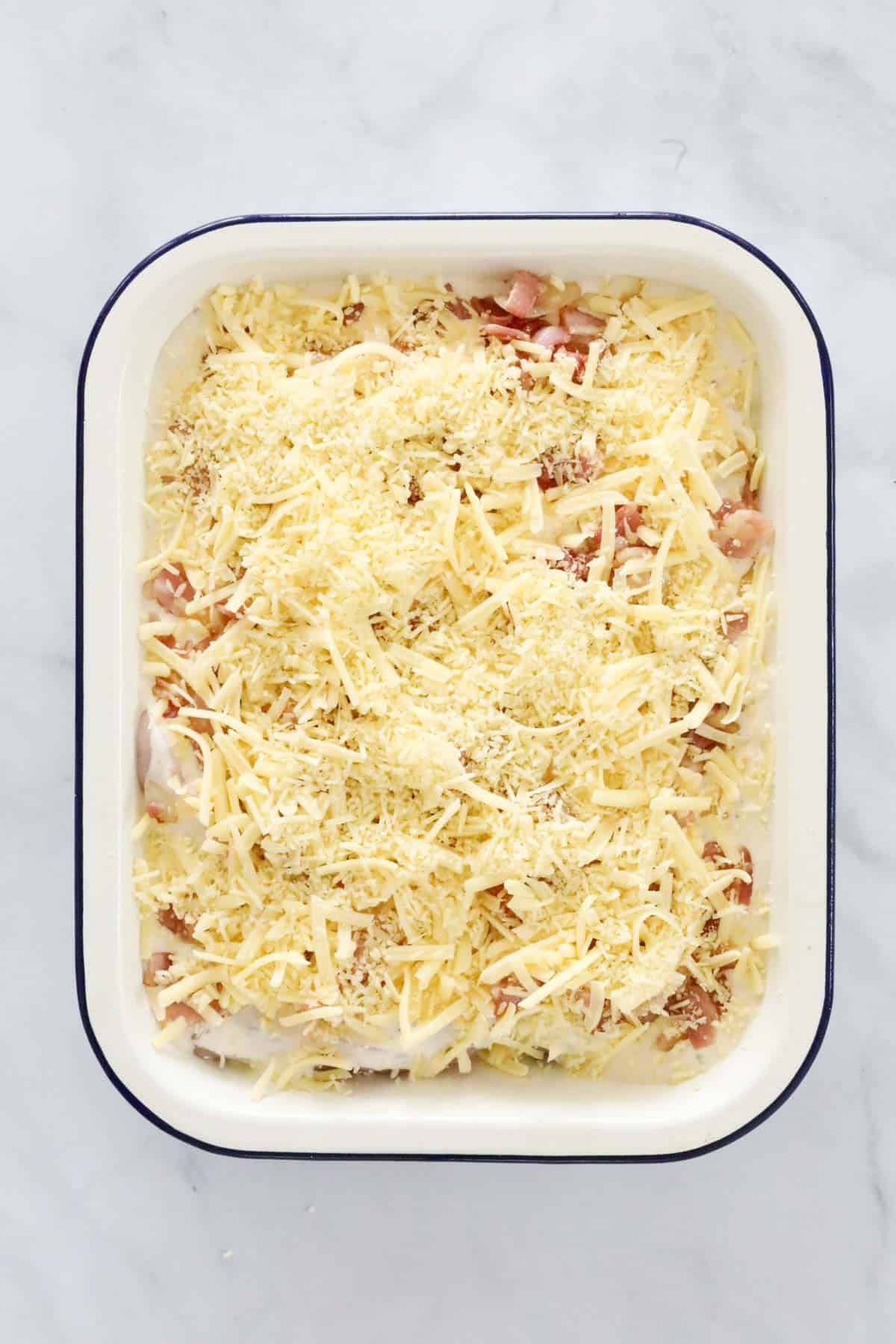 Grated parmesan and cheddar cheese sprinkled over the top of a chicken dish.
