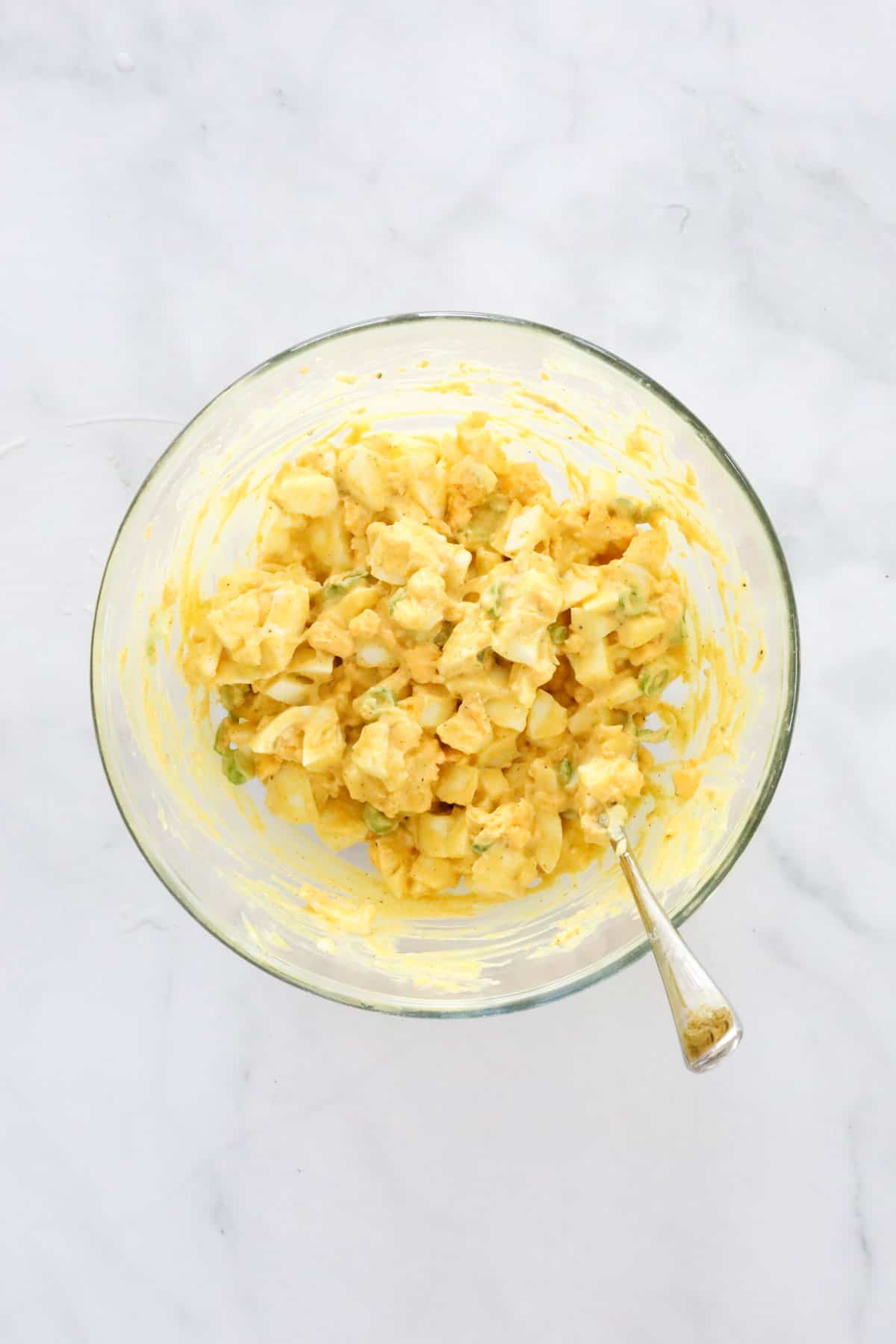 Chopped egg and dressing mixed together in a bowl.