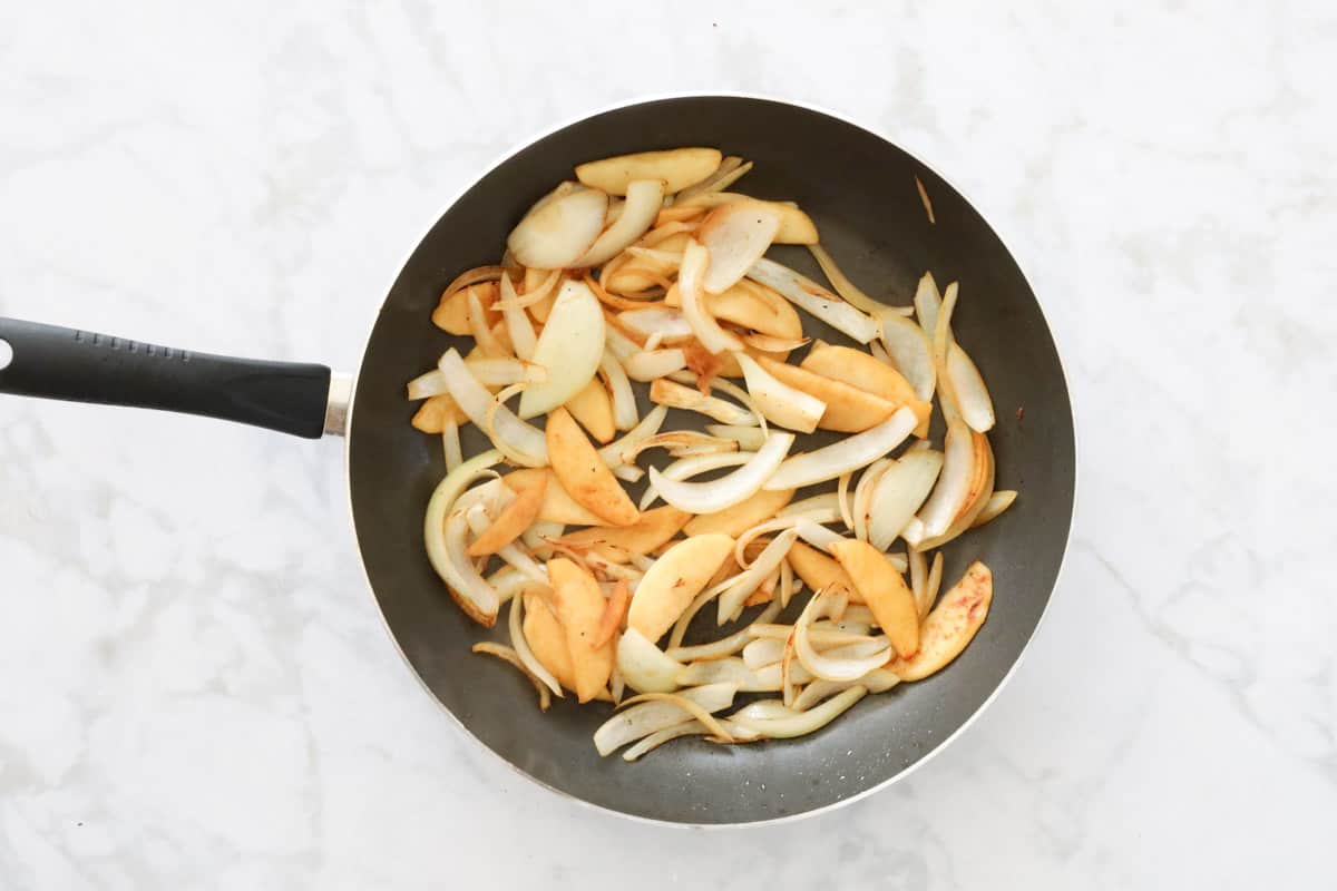 Browned onion and apple in a pan.