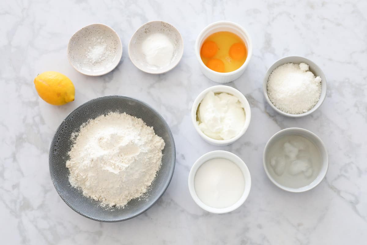 All the ingredients for a lemon loaf in individual bowls