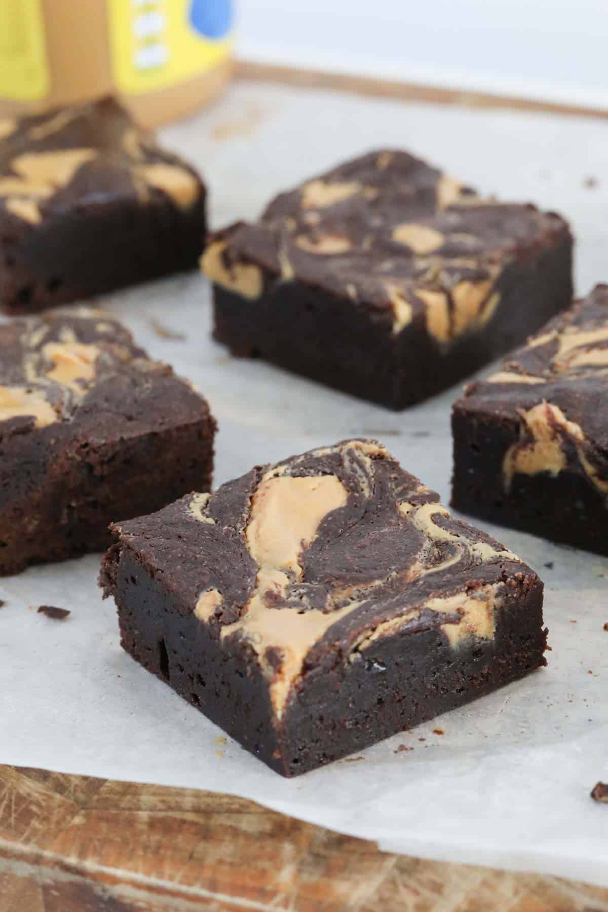 Squares of peanut butter brownies placed on baking paper.