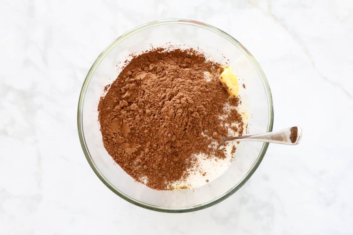 Cocoa added to butter mixture in a bowl.