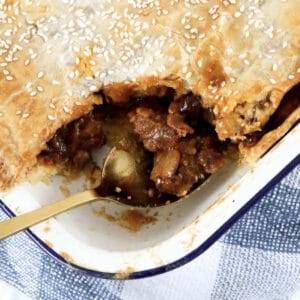 An overhead shot of steak and mushroom pie with flakey pastry.