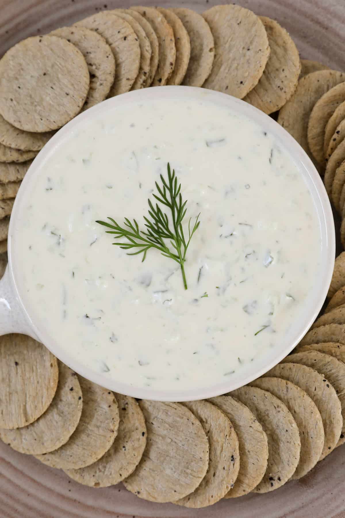 An overhead shot of a bowl of Greek dip with fresh dill on top. 
