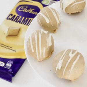 An overhead shot of cheesecake balls coated in Caramilk chocolate.
