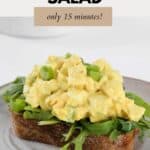 Curried egg salad on a bed of lettuce on a slice of rye bread.