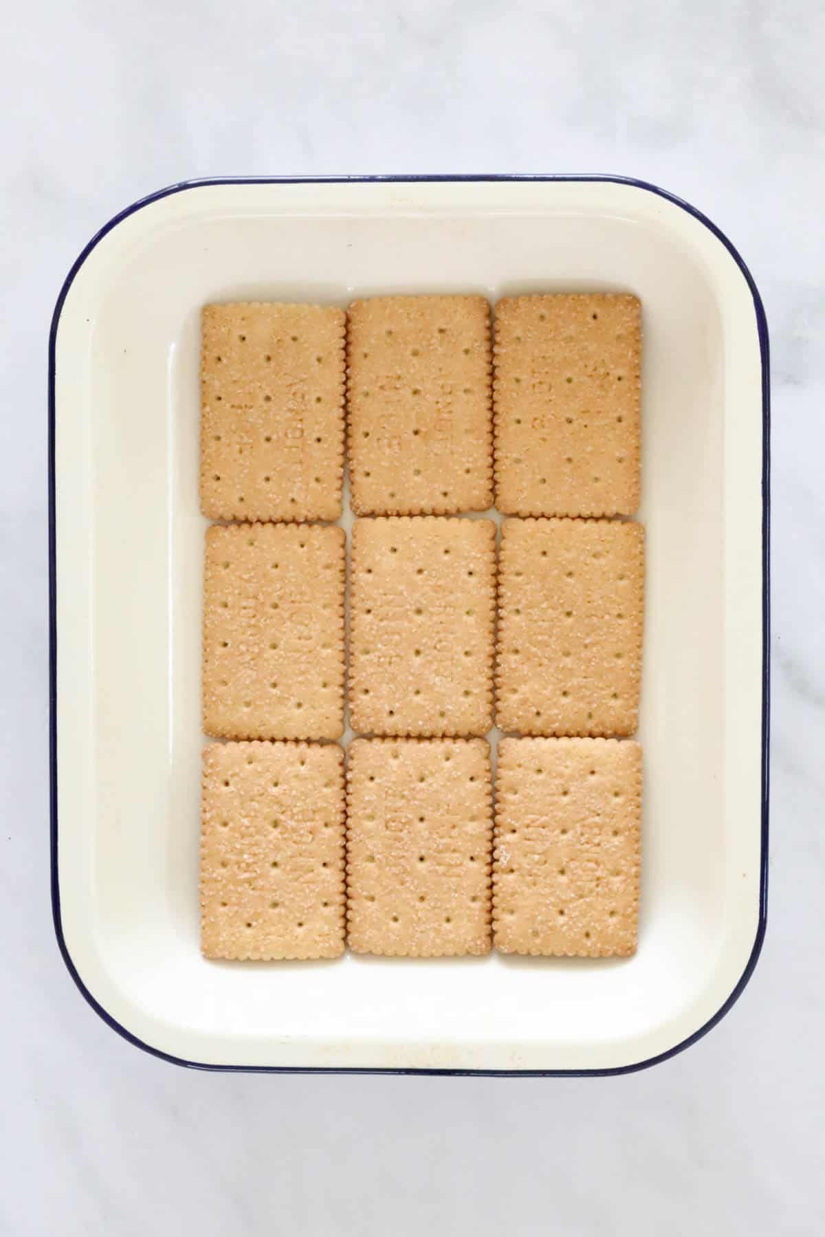 Nine biscuits laid out in the bottom of a dish.