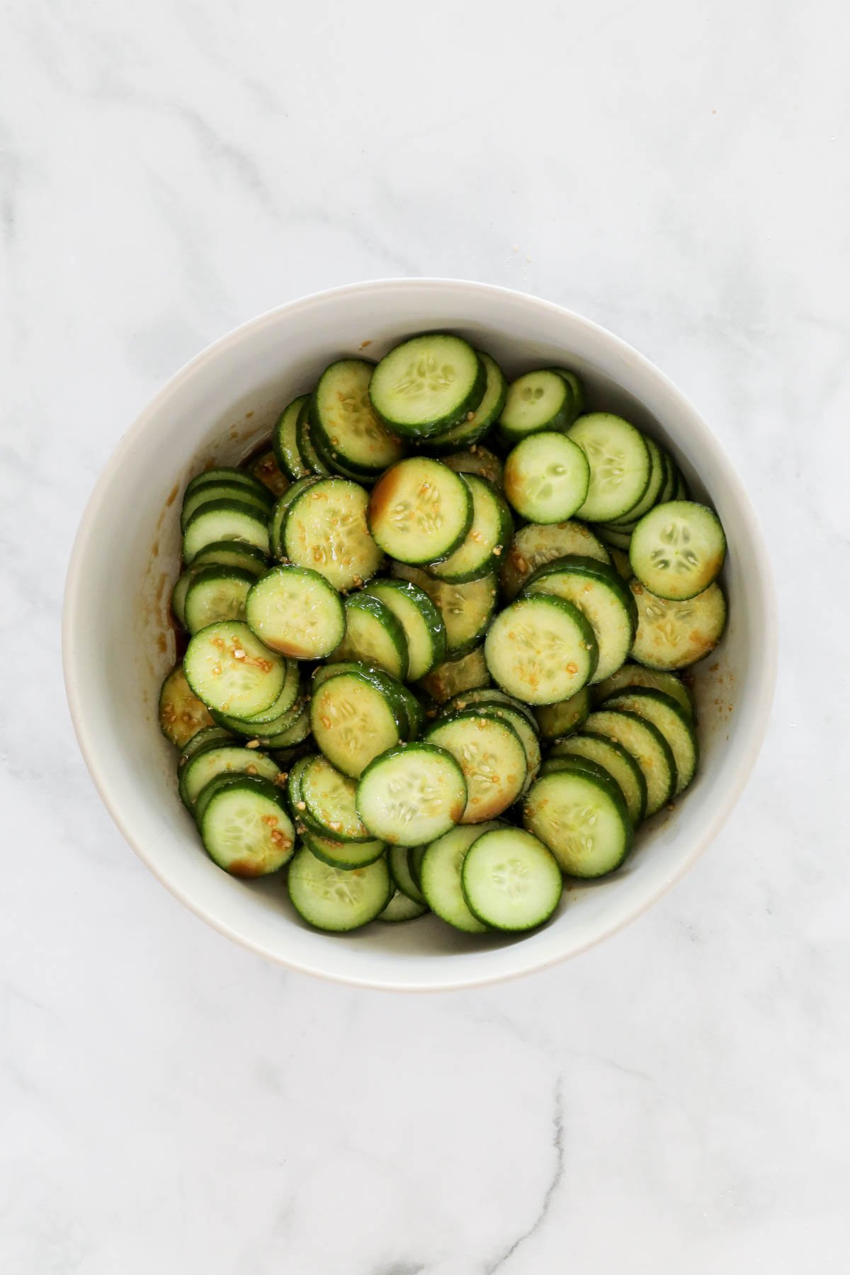 Cucumbers and dressing in a bowl.