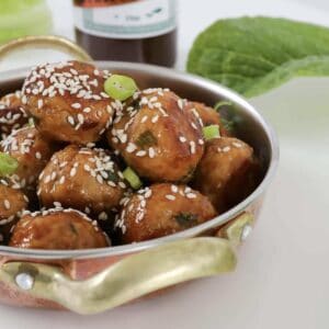 A bowl filled with turkey meatballs coated in hoisin and soy sauce.