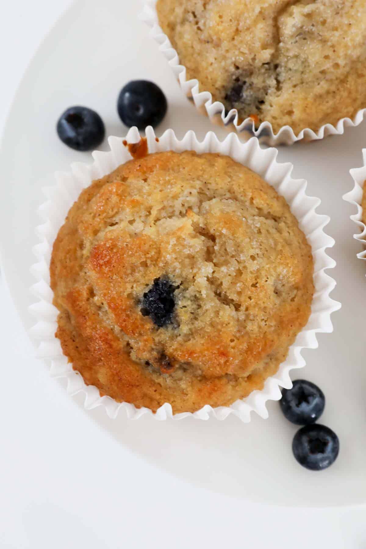 Banana blueberry muffins in white muffin liners.