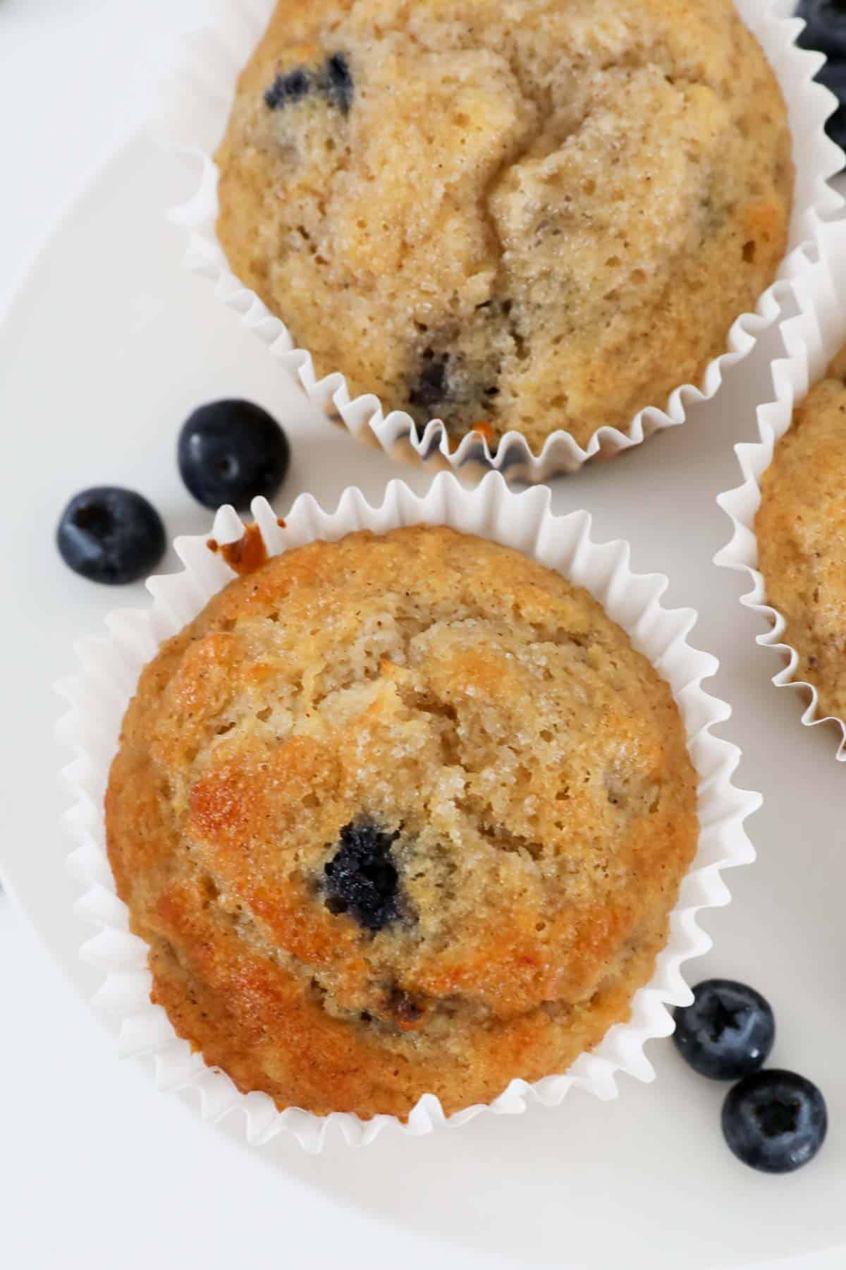 Banana blueberry muffins in white muffin liners.