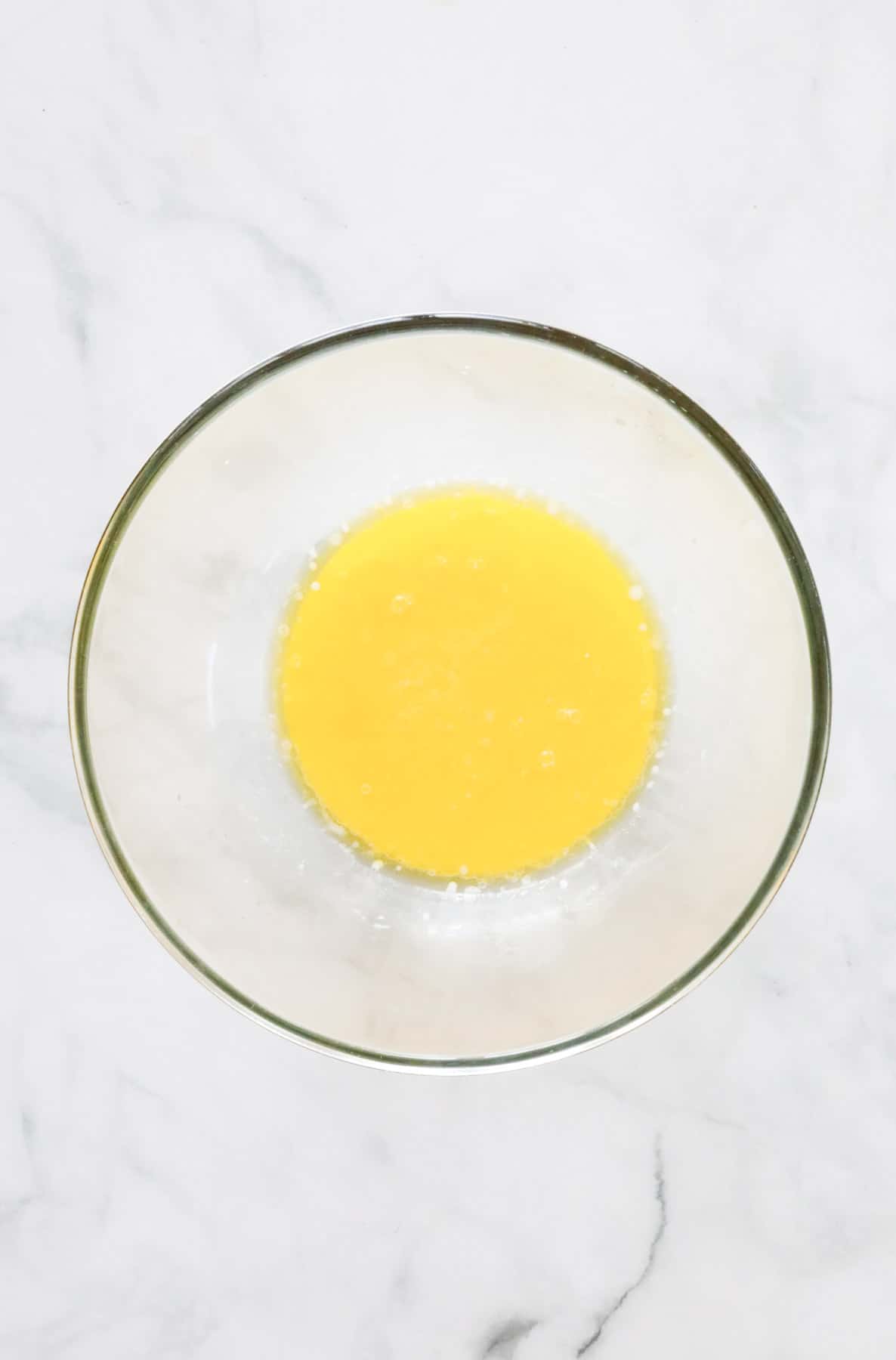 Milk and honey mixed with melted butter in a glass bowl.