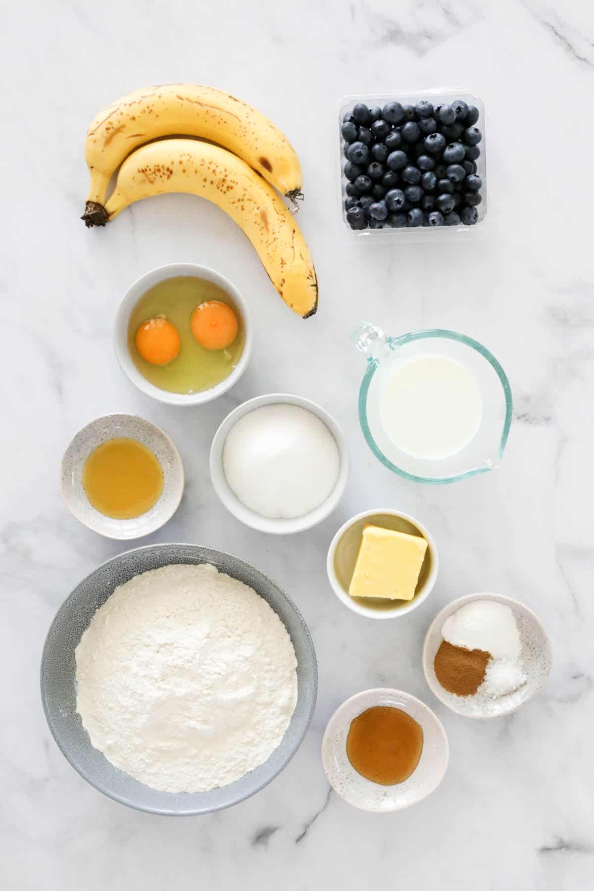 Ingredients for making banana blueberry muffins in bowls.