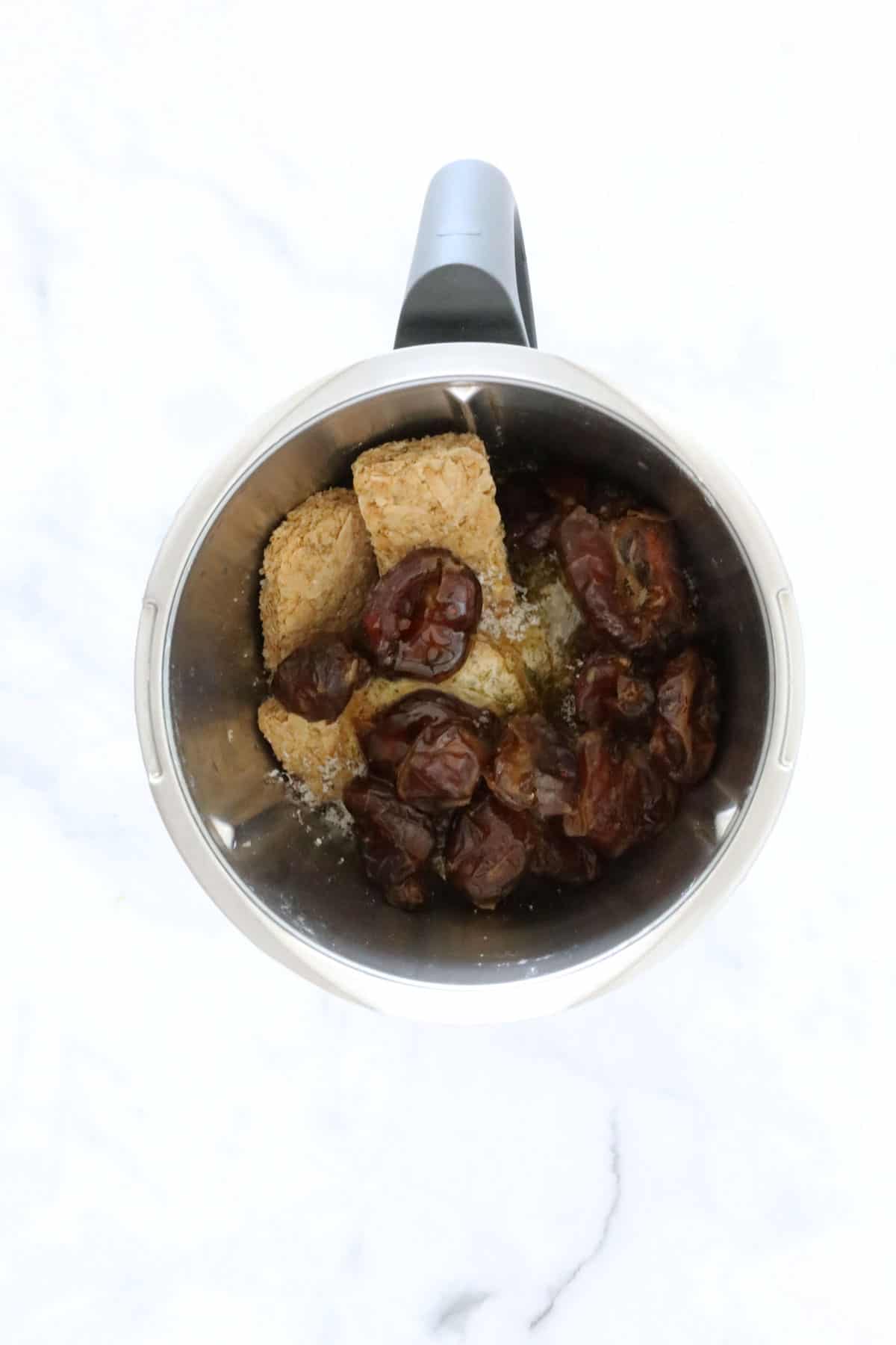 Weet-Bix, dates, sultanas, honey and coconut placed in a bowl.