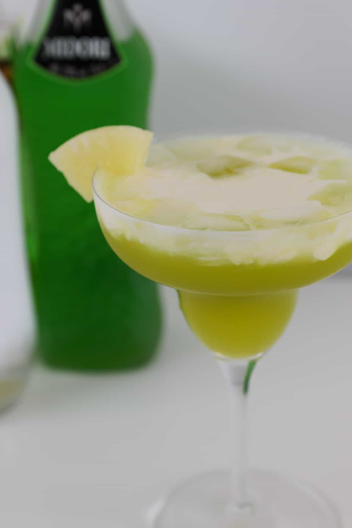 A pineapple slice garnishing a pine lime cocktail.
