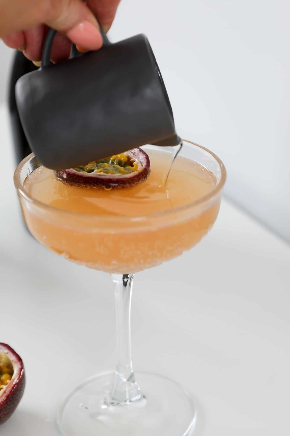 Prosecco being poured into a pornstar martini.