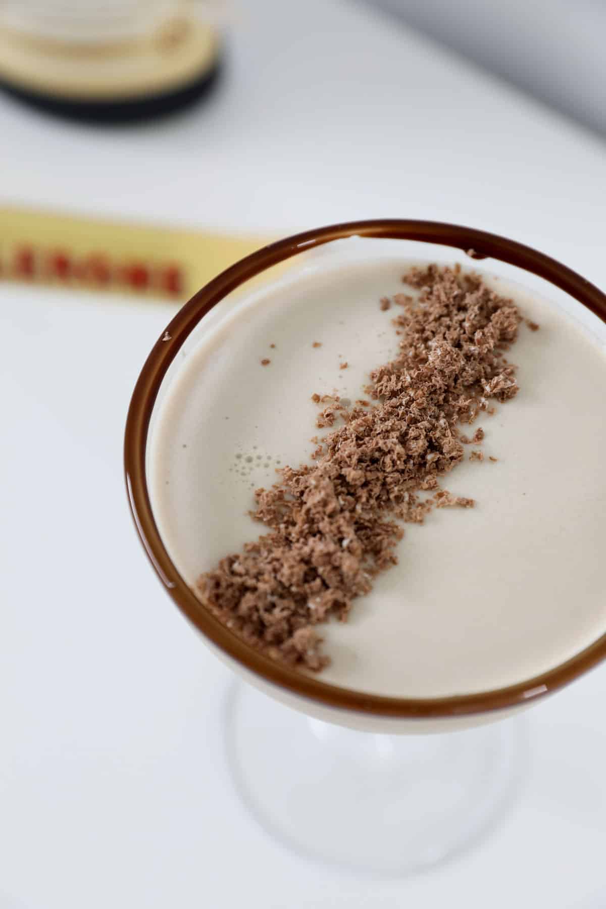 An overhead shot of a creamy cocktail topped with grated Toblerone.