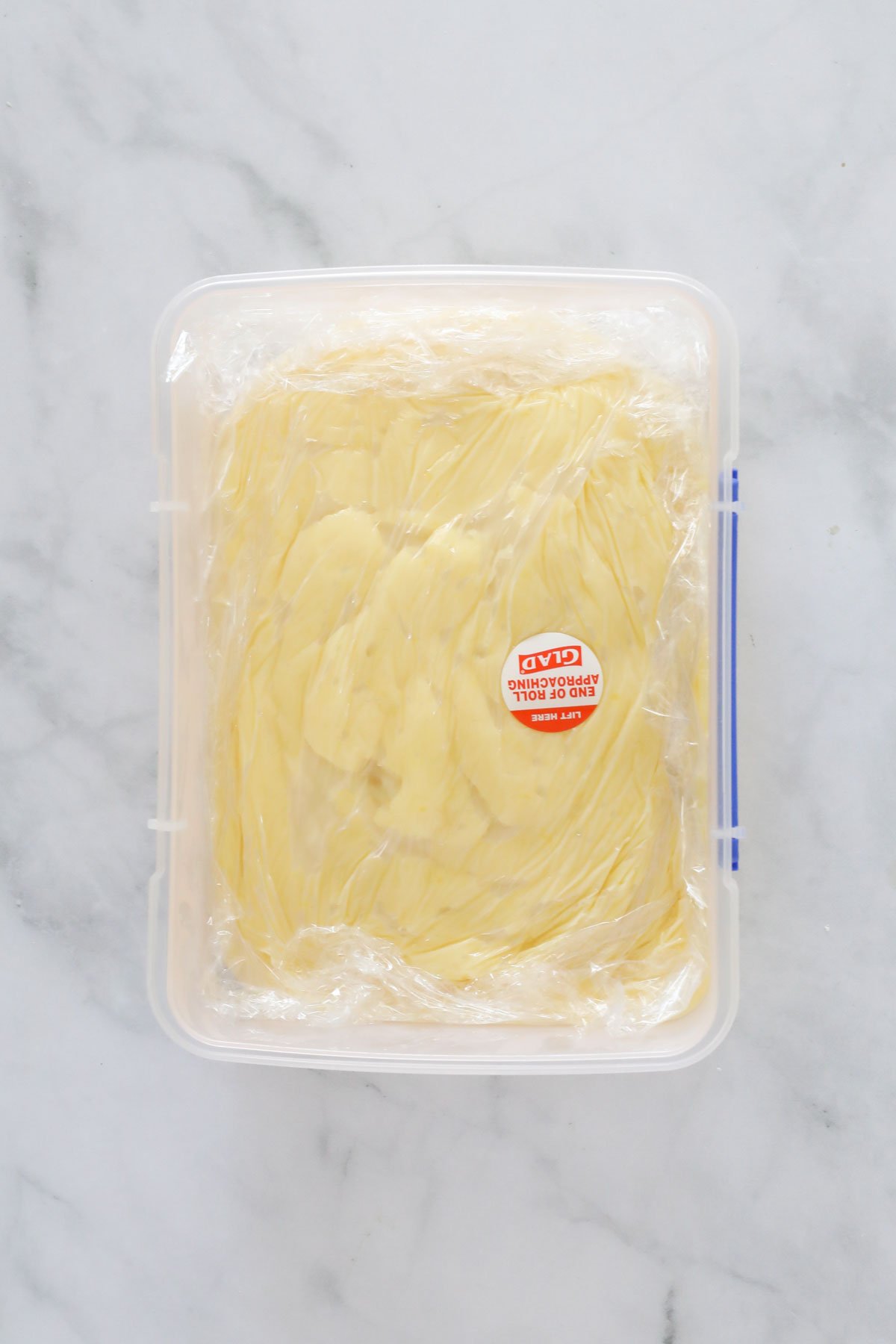 Custard in a container covered with plastic wrap.