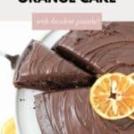 A chocolate orange cake with one slice partly removed.
