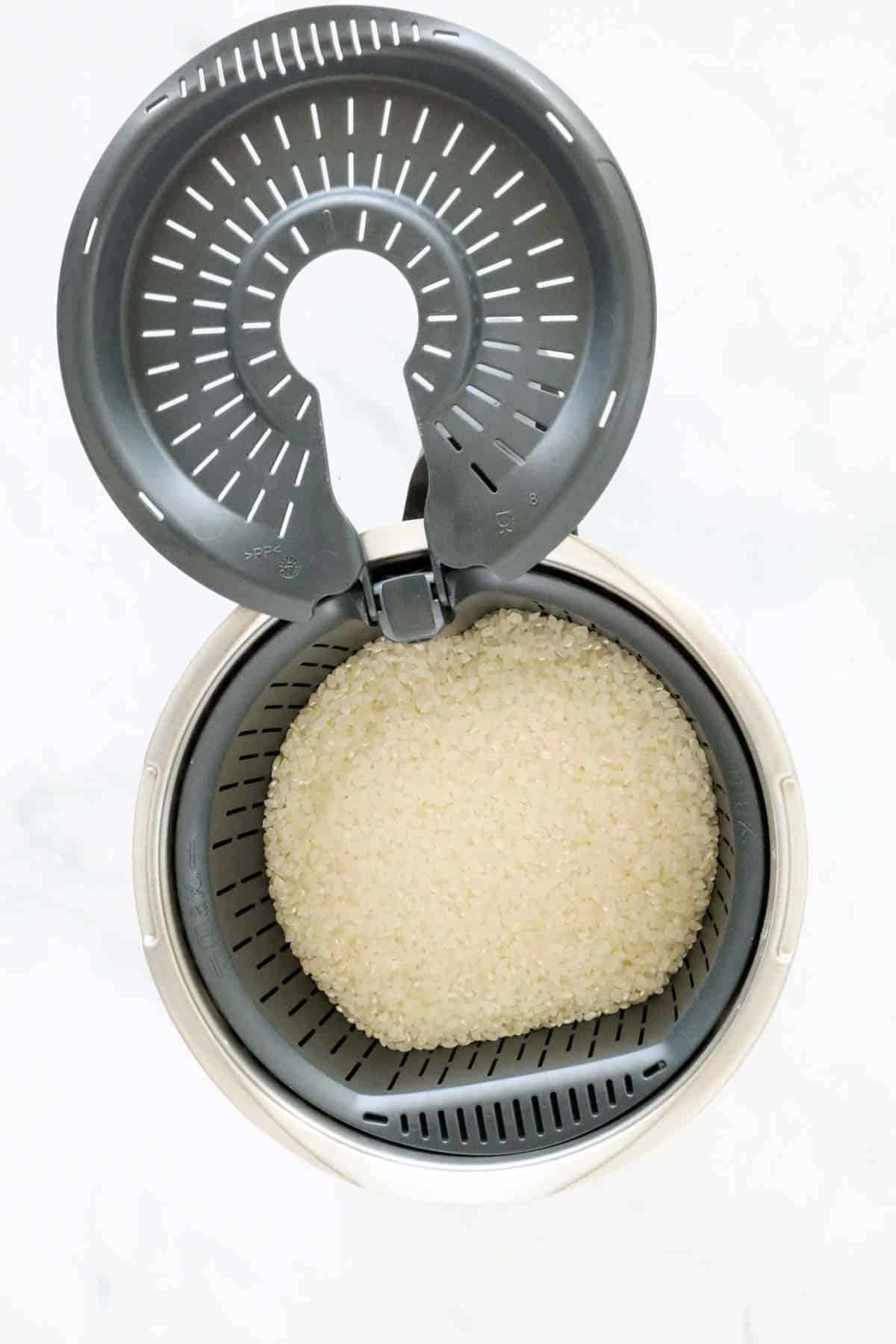 Uncooked rice in a Thermomix simmering basket.
