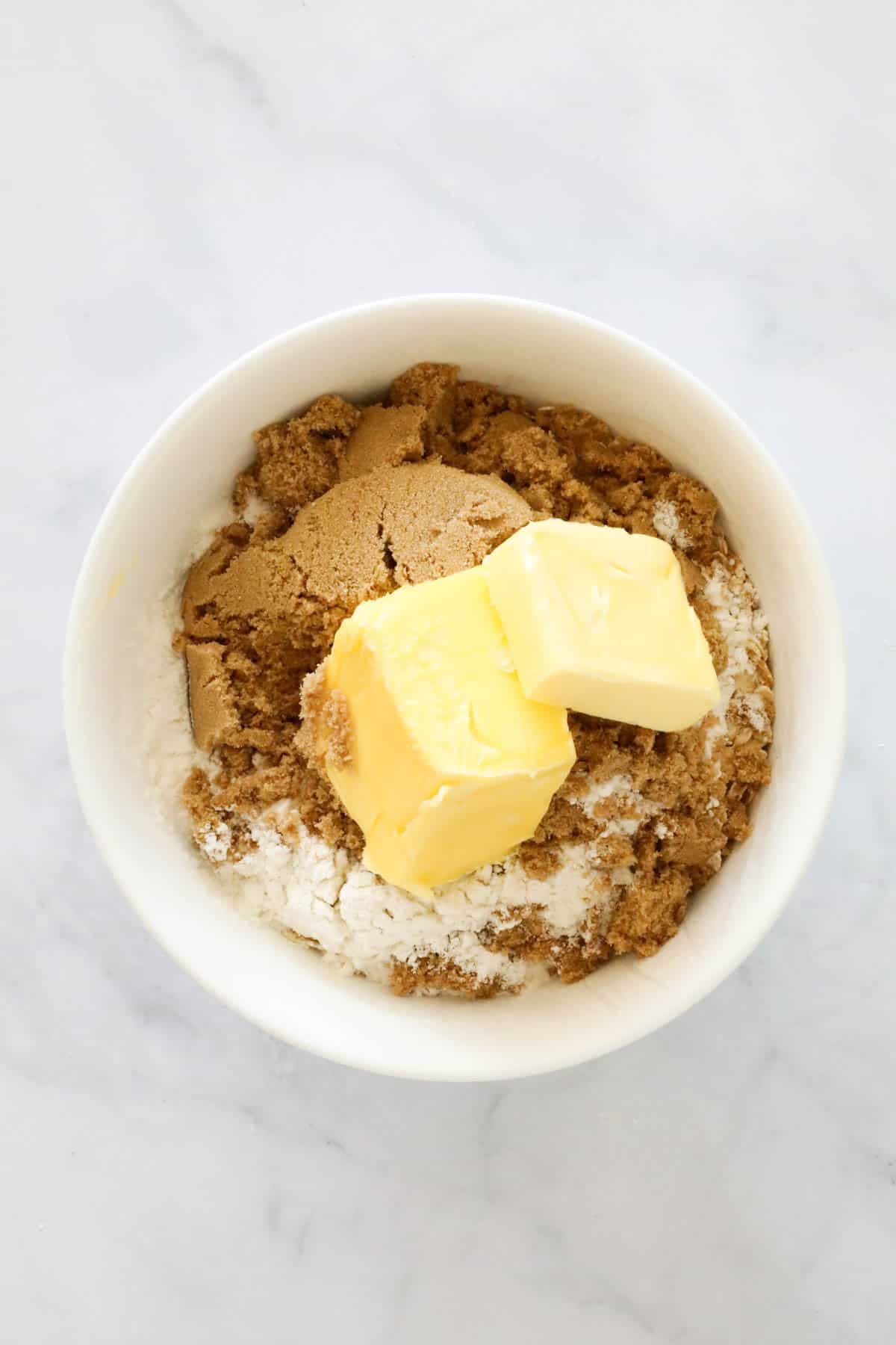 Butter, brown sugar and flour in a bowl.