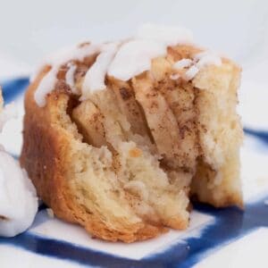 A half eaten sweet scroll with apple and cinnamon.