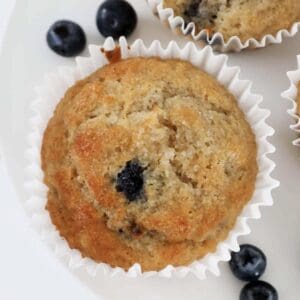 An overhead shot of a crunchy sugar topped banana muffin with blueberries.