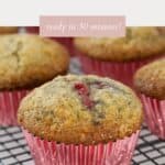 Banana Raspberry Muffins in pink cases, cooling on a wire tray.