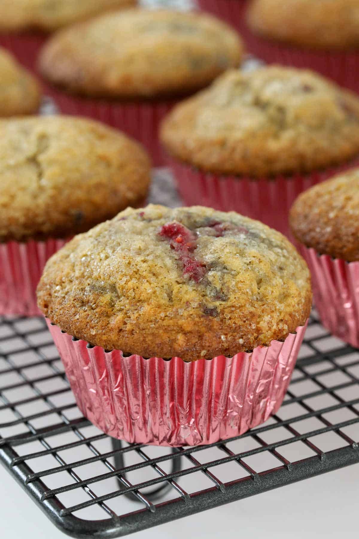 Banana raspberry muffins baked in shiny pink paper cases.