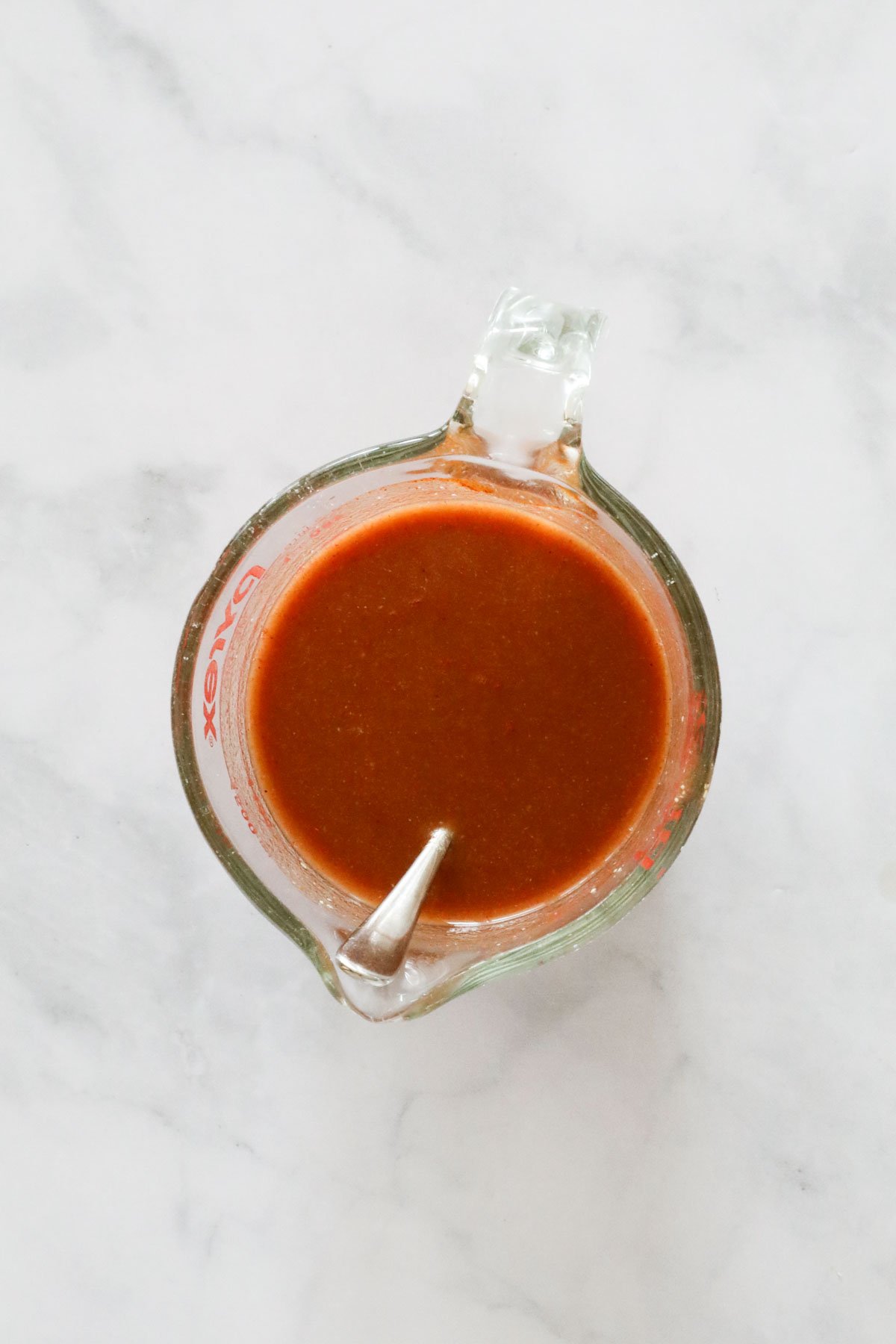 Stock, tomato paste and seasonings, mixed in a jug.