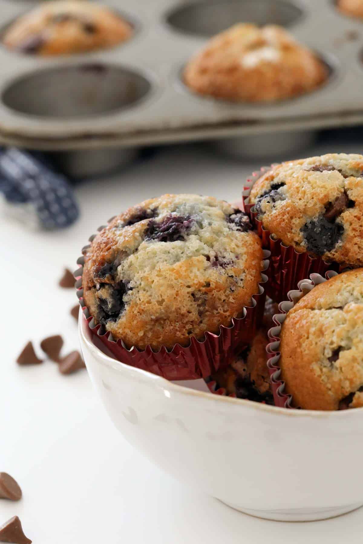 A bowl of muffins in metallic pink paper cases.