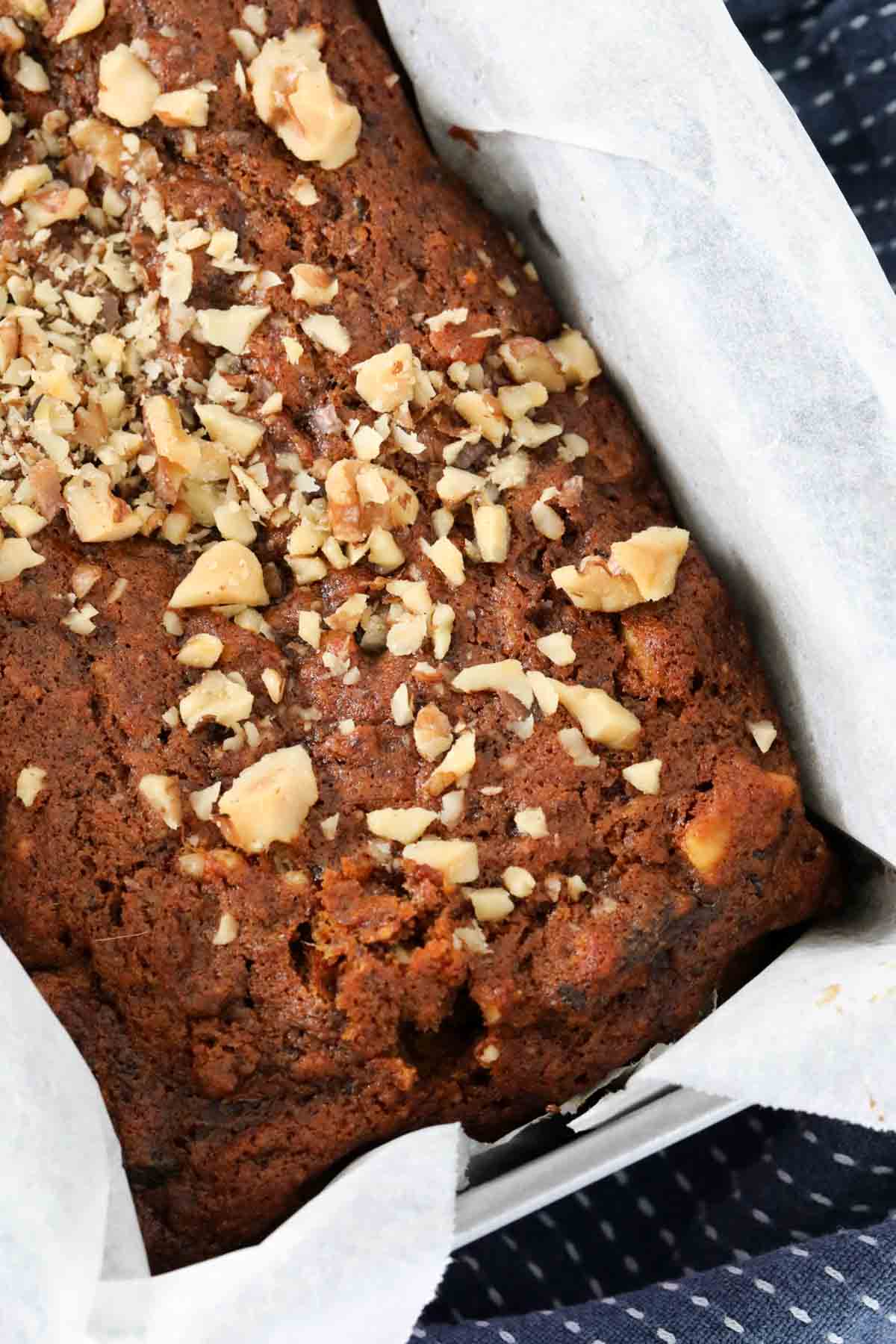 A close up showing walnuts sprinkled over a date loaf.