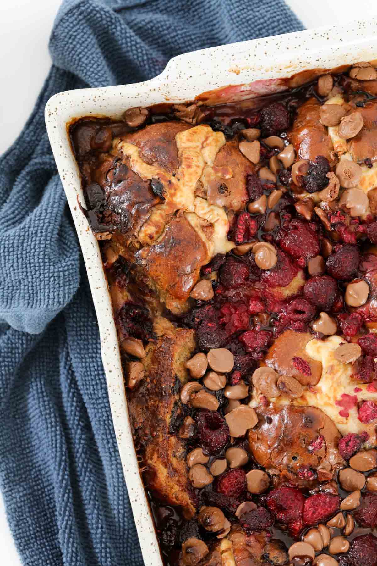 An overhead shot of raspberries and chocolate chips in a bread pudding.