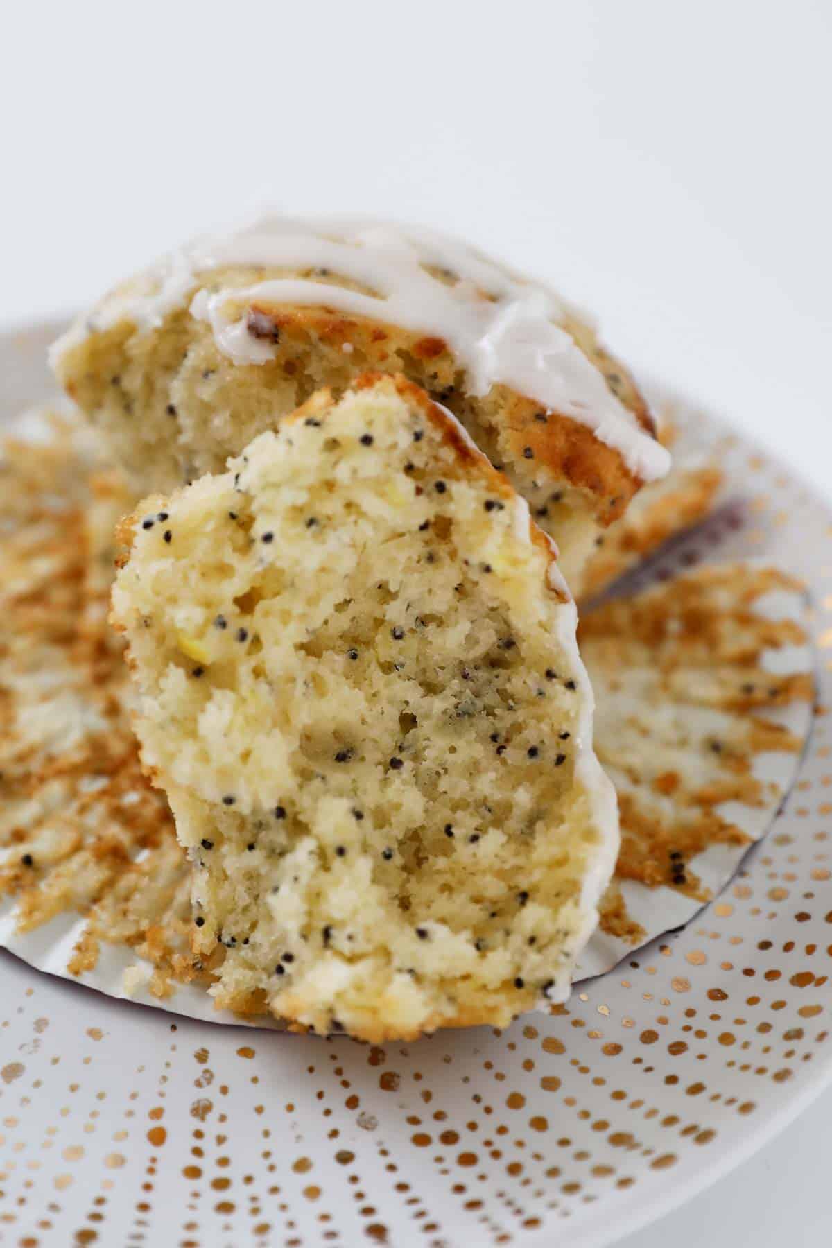 A poppyseed muffin split in half with the fluffy inside showing