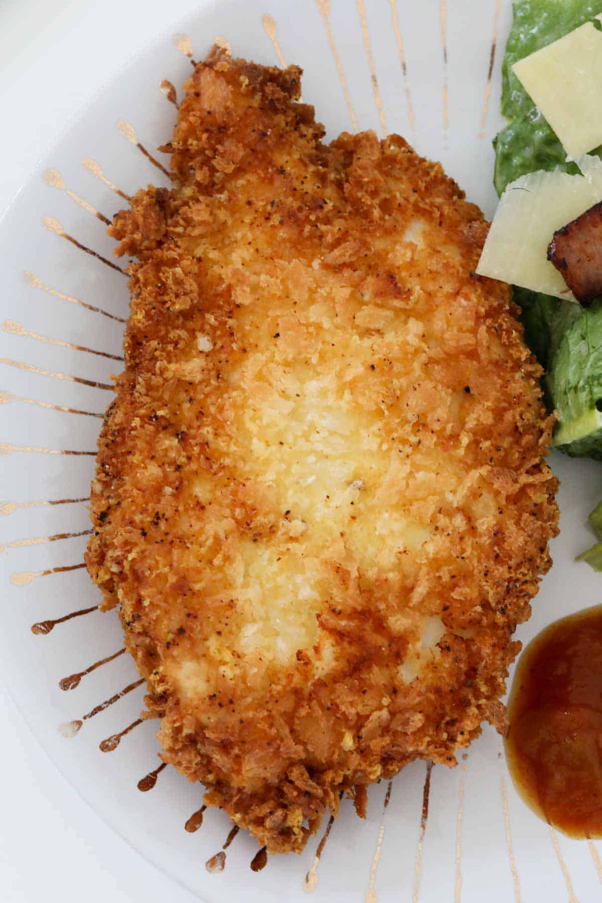 Crispy crumbed chicken fillets served with a salad.