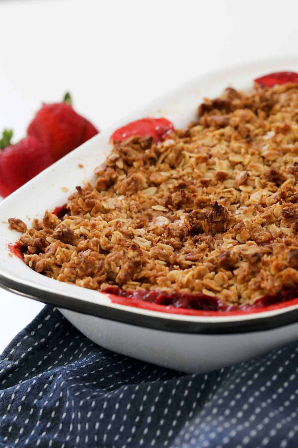 Baked fruit crumble in a white baking dish.